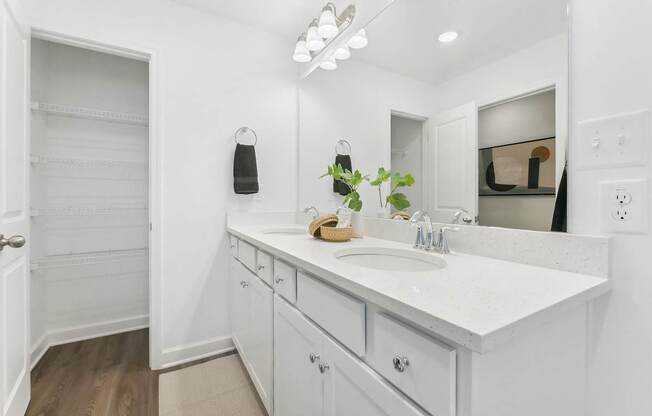 a bathroom with white cabinets and a sink and a mirror