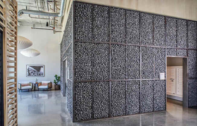 A room with a black and white patterned wall and a wooden staircase.