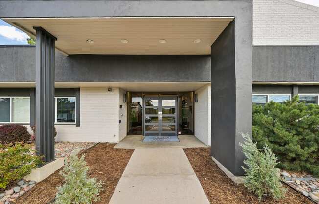 A modern building with a concrete facade and a covered walkway leading to the entrance.