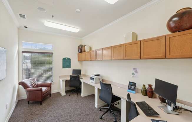an office with two desks and computers and a chair
