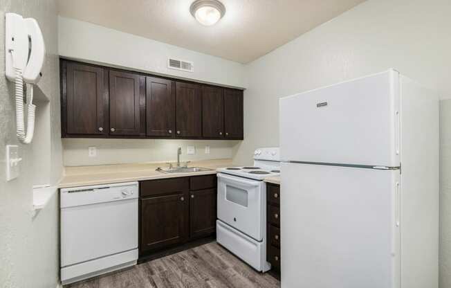 a kitchen with white appliances and dark wood cabinets