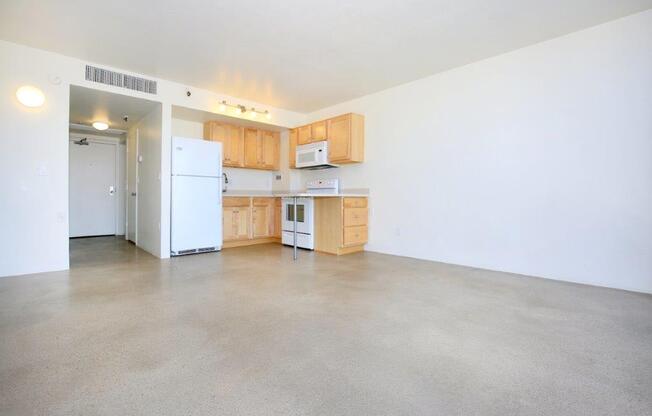 A kitchen with white appliances and wooden cabinets.