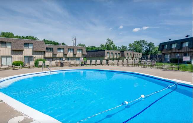 a large swimming pool with apartments in the background