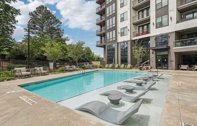 A large swimming pool in front of apartment buildings.