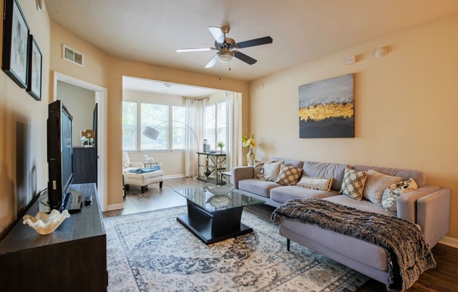 a living room with a couch and a coffee table and a ceiling fan