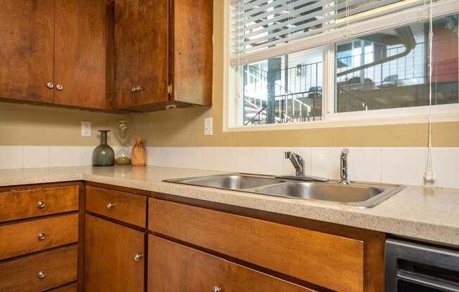 A kitchen with wooden cabinets and a stainless steel sink.