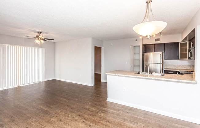 A kitchen area with a bar counter and a ceiling fan.