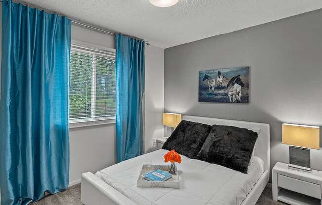 a bedroom with a white bed and blue curtains