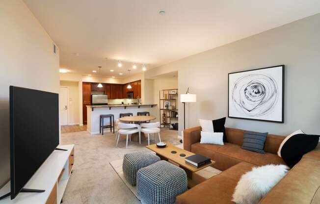 a living room and kitchen with a couch and a tv