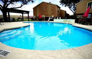 a swimming pool with a brick building in the background