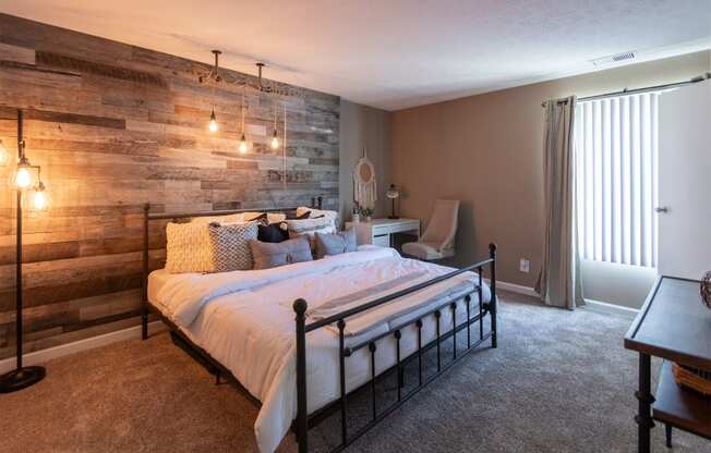 This is a photo of the bedroom with barb wood wall in the upgraded 650 square foot, 1 bedroom, 1 bath model apartment at Deer Hill Apartments in Cincinnati, Ohio.