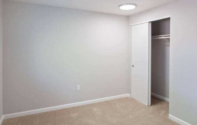 A room with a white door and a carpeted floor.