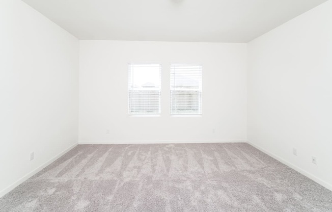 bright bedroom with a carpeted floor and two windows