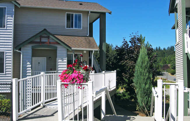 A house with a white fence and pink flowers.