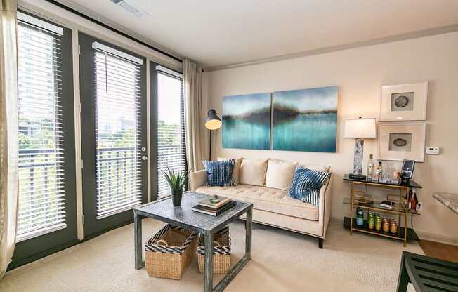 A living room with a white couch and a large painting on the wall.