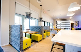 a seating area with yellow chairs and tables in a restaurant