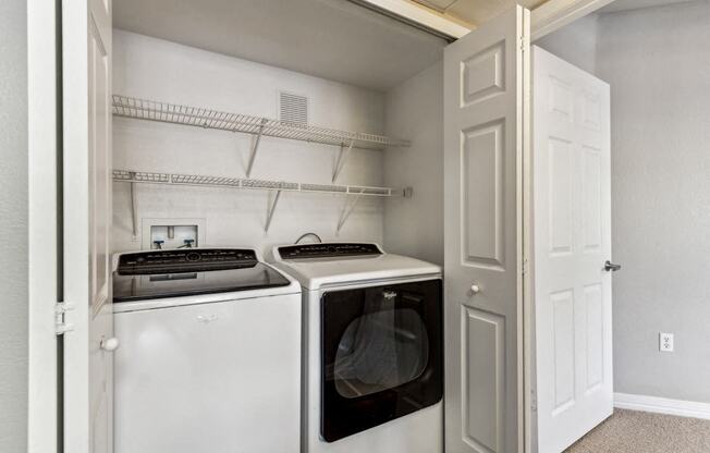 a white washer and dryer in a laundry room with a white door