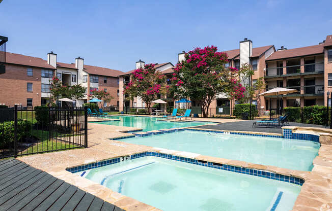 A pool surrounded by buildings and trees.