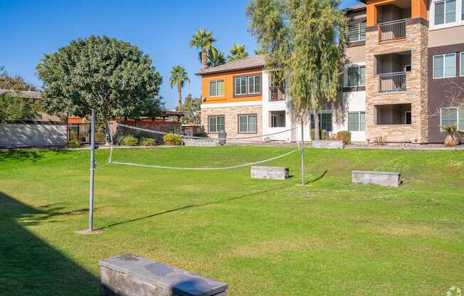 A grassy area in front of apartment buildings with a soccer goal in the middle.