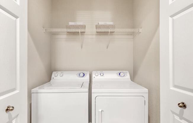 A small laundry room with a washer and dryer.