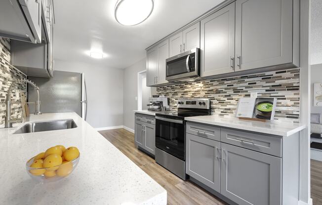 a kitchen with stainless steel appliances and white counter tops