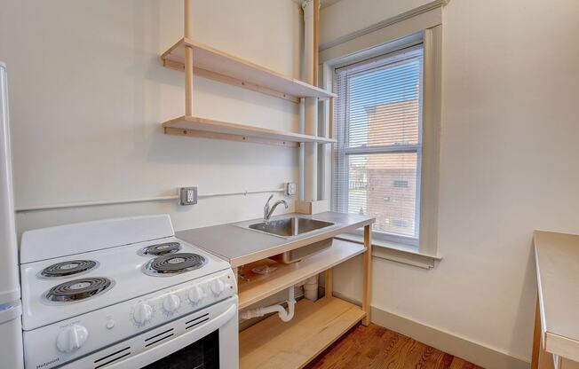 a kitchen with a stove and sink and a window