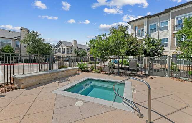 A small pool in a courtyard surrounded by a fence.