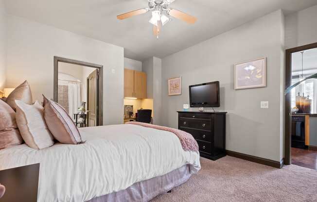 a bedroom with a large bed and a ceiling fan