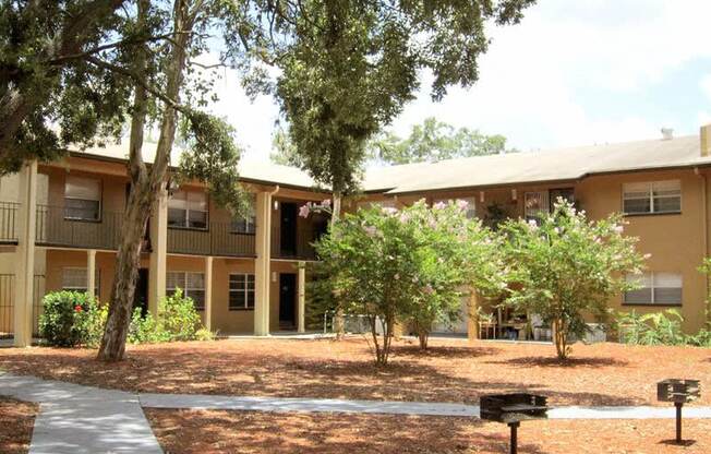 an apartment building with a courtyard and trees in front of it