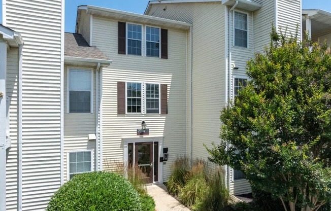 A white house with a brown door and windows.