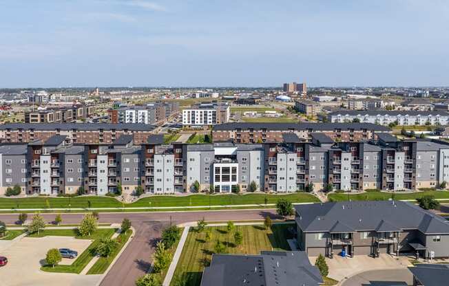 A large apartment complex with a parking lot in front.