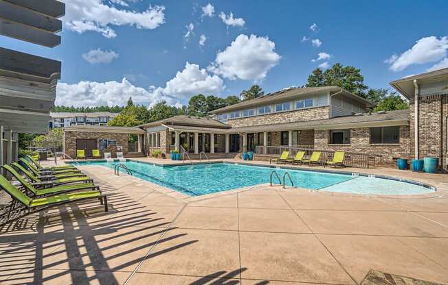 a swimming pool with lounge chairs and a building with a pool