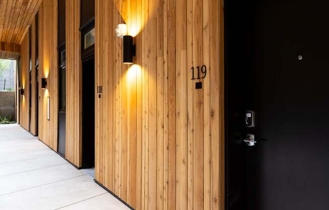 the lobby of the building has wooden walls and black doors