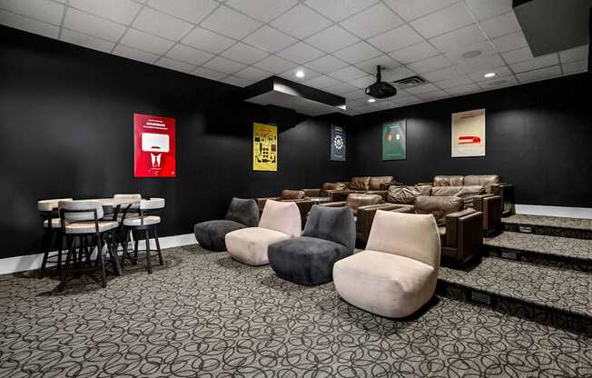 A room with black walls and a patterned carpet with several chairs and a table.