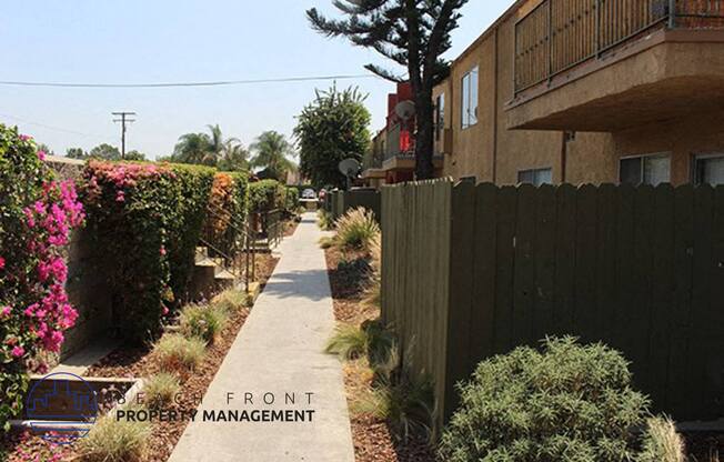 a sidewalk next to a fence and a building