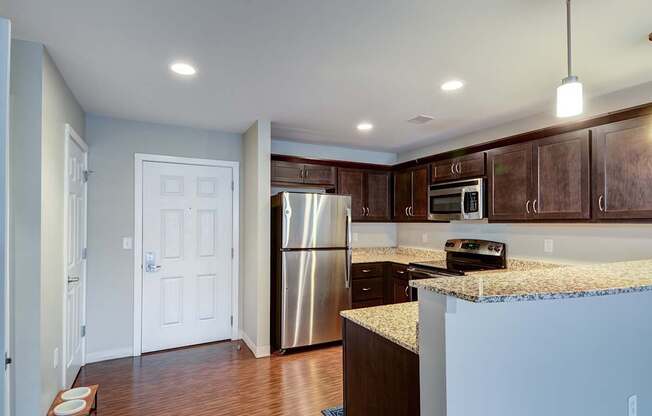 A kitchen with a stainless steel refrigerator and microwave.