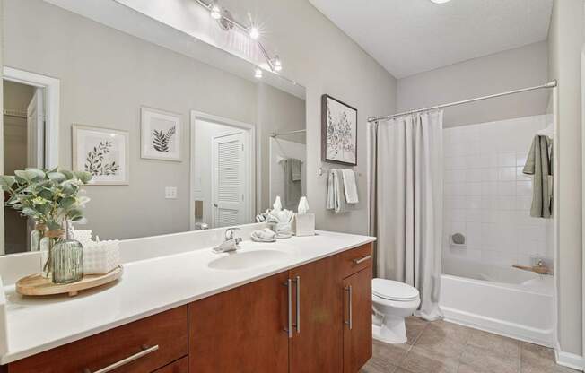 A bathroom with a white countertop and a white sink.