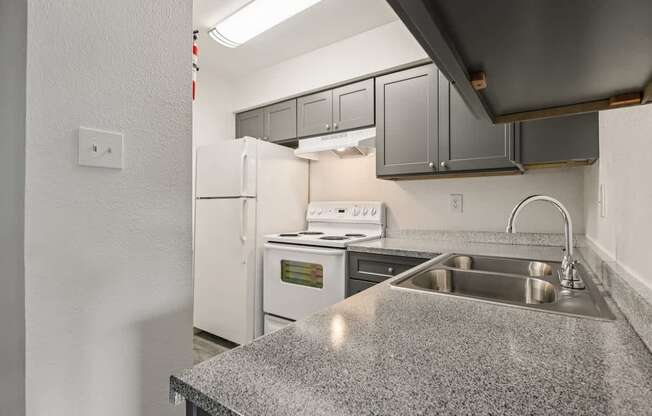 A kitchen with a granite countertop and stainless steel appliances.