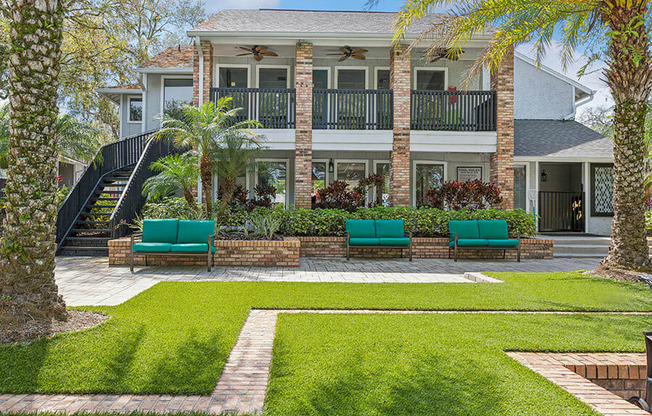 Exterior Community Clubhouse and Landscape with Lounge Furniture at Grand Pavilion Apartments in Tampa, FL.