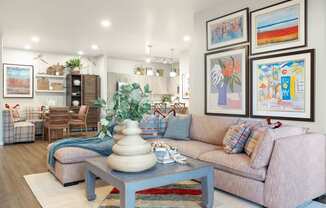 A living room with a couch, coffee table, and pictures on the wall.