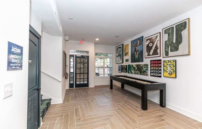 a gallery with paintings on the wall and benches in a room