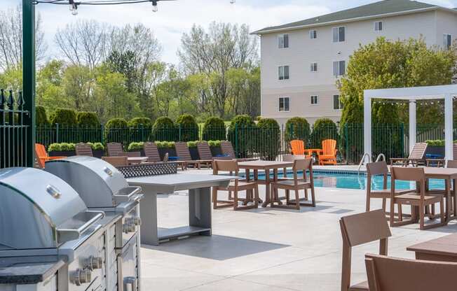 an outdoor patio with tables and chairs and a swimming pool