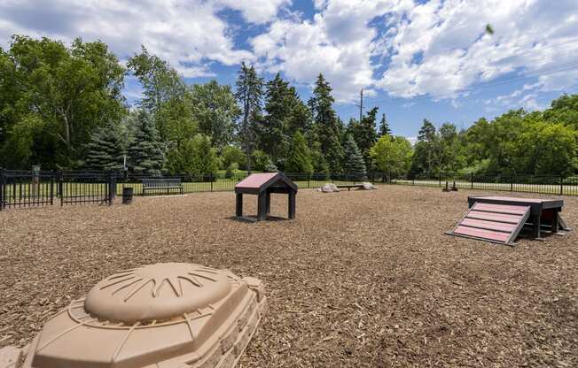 a playground with a sandbox and a picnic table in a park