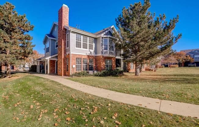 a large brick house with a sidewalk in front of it