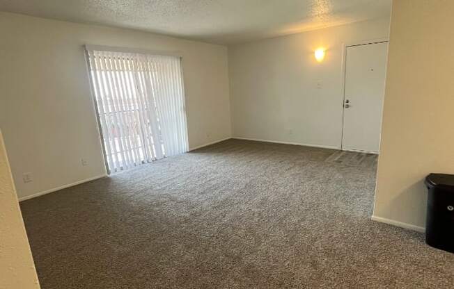 an empty living room with a sliding glass door