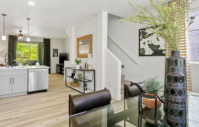 a living room with a glass table and a kitchen