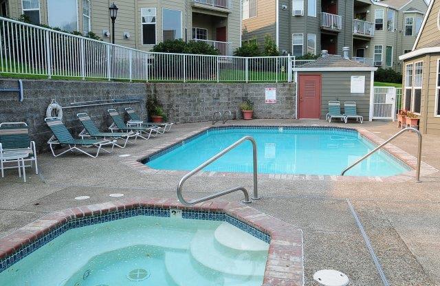 a swimming pool with an apartment building in the background