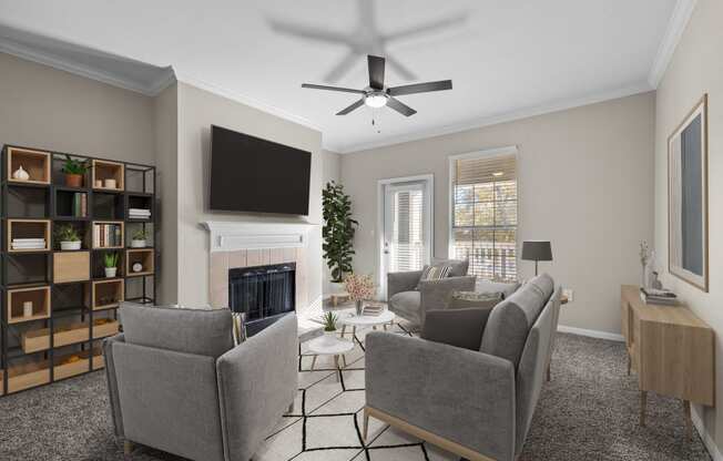 a living room with a ceiling fan and couches