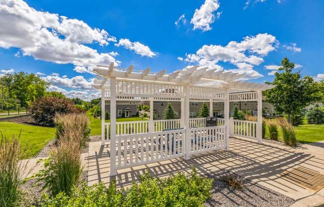 a white gazebo with white benches and a white pavilion