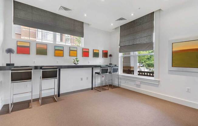 a kitchen with a counter and chairs in front of a window